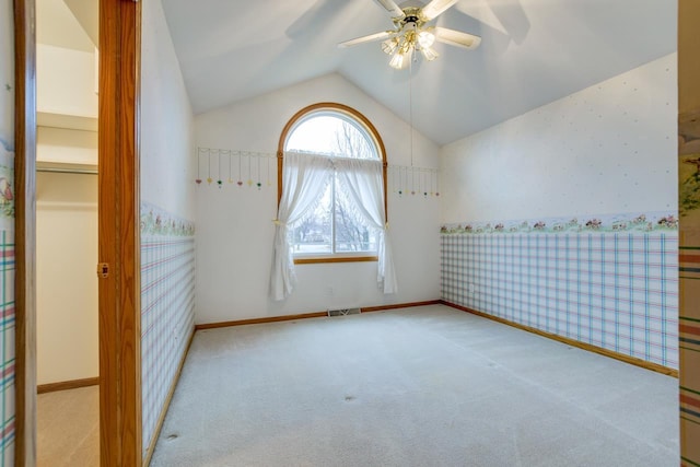 unfurnished room with ceiling fan, light colored carpet, and vaulted ceiling