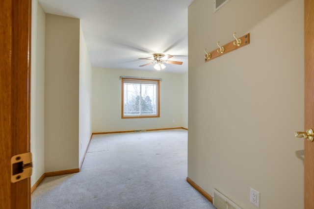 spare room featuring light carpet and ceiling fan