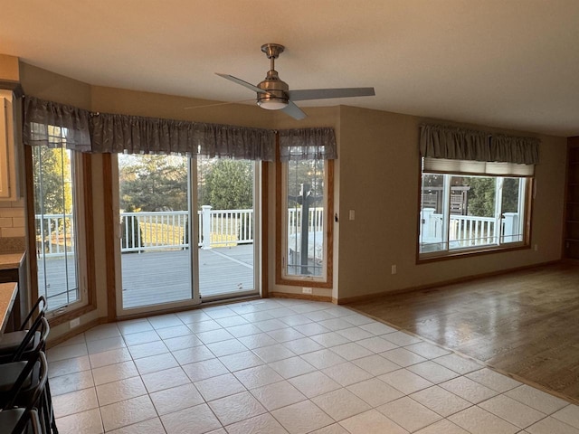 interior space with light tile patterned floors and ceiling fan