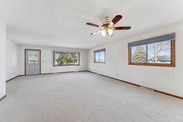 spare room with ceiling fan and light carpet