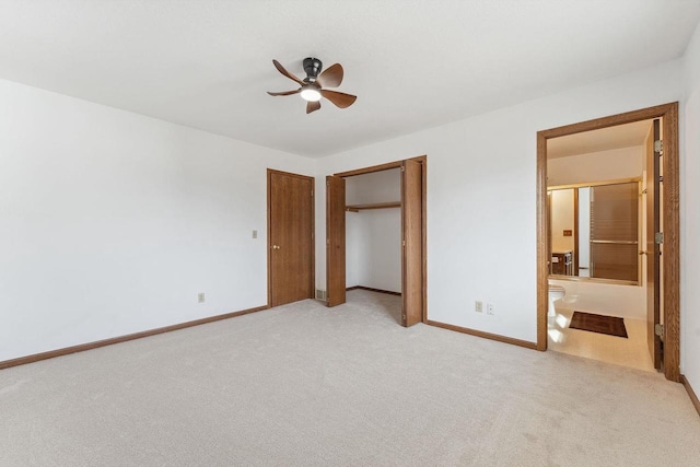 unfurnished bedroom with ceiling fan, light colored carpet, and ensuite bathroom