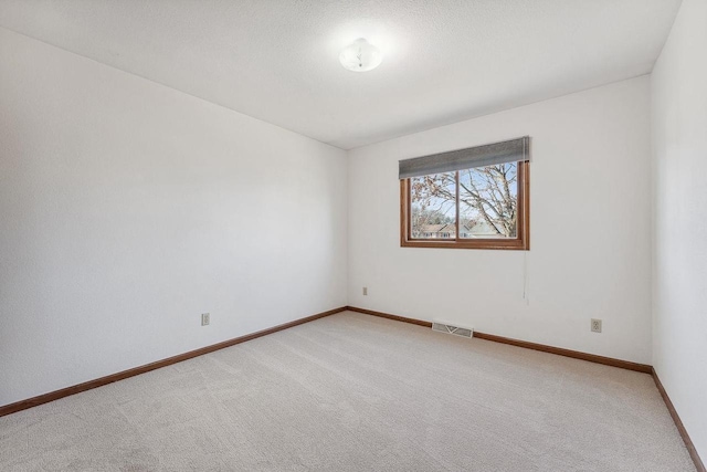 carpeted spare room with a textured ceiling