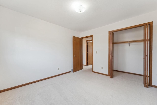 unfurnished bedroom with a closet and light carpet