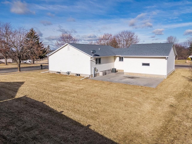 back of property with a yard, a patio, and central air condition unit