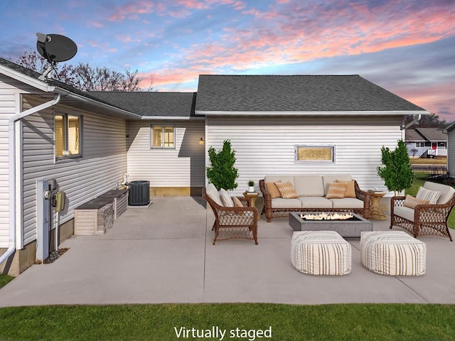 patio terrace at dusk with an outdoor living space with a fire pit and cooling unit