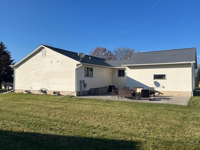 rear view of property with a yard and a patio