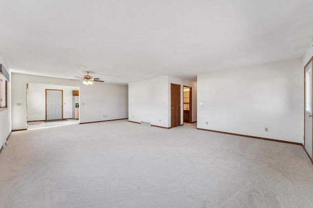 empty room featuring ceiling fan and light carpet