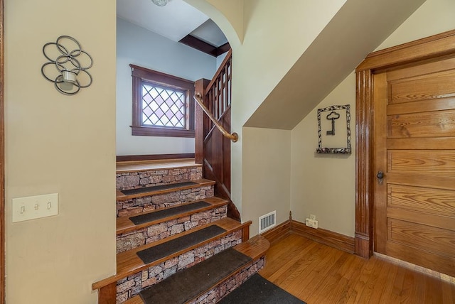 stairs with lofted ceiling and wood-type flooring