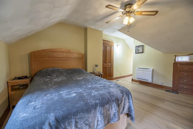 bedroom with heating unit, vaulted ceiling, light hardwood / wood-style floors, and ceiling fan