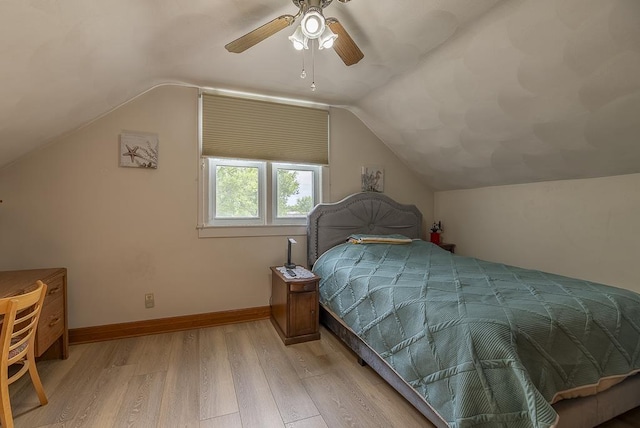 bedroom with ceiling fan, vaulted ceiling, and light hardwood / wood-style flooring