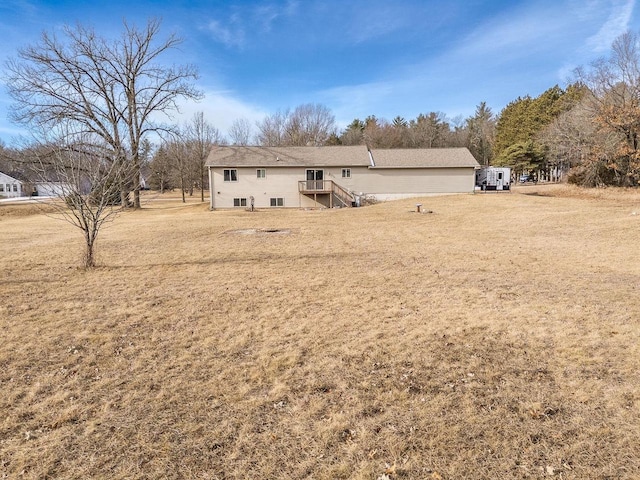 back of property with a wooden deck and a yard