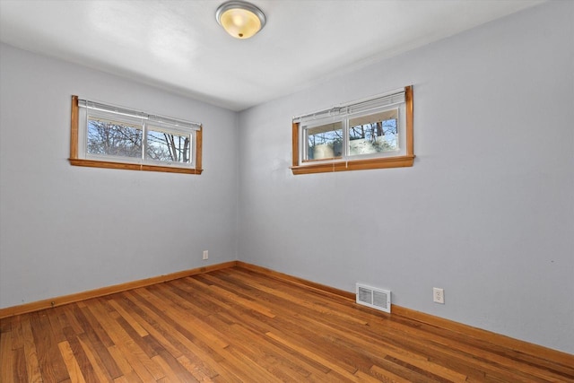 empty room featuring a healthy amount of sunlight and wood-type flooring