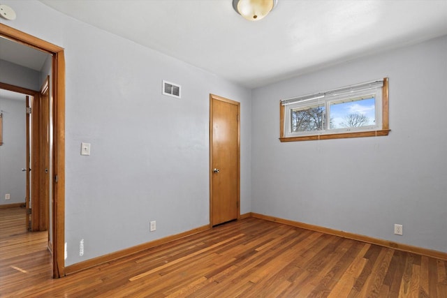 unfurnished bedroom with wood-type flooring and a closet