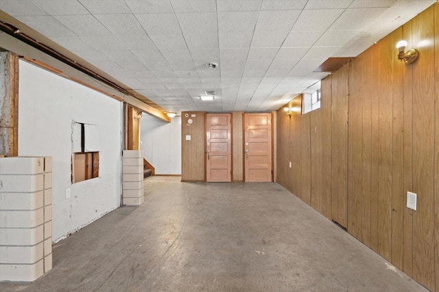 basement featuring wood walls