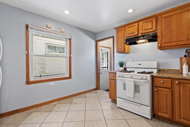 kitchen with white gas range and light tile patterned floors