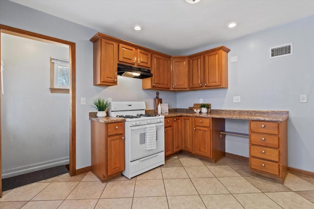 kitchen with light stone countertops, white range with gas cooktop, and light tile patterned floors