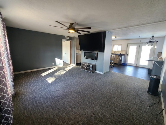 unfurnished living room with ceiling fan and dark carpet