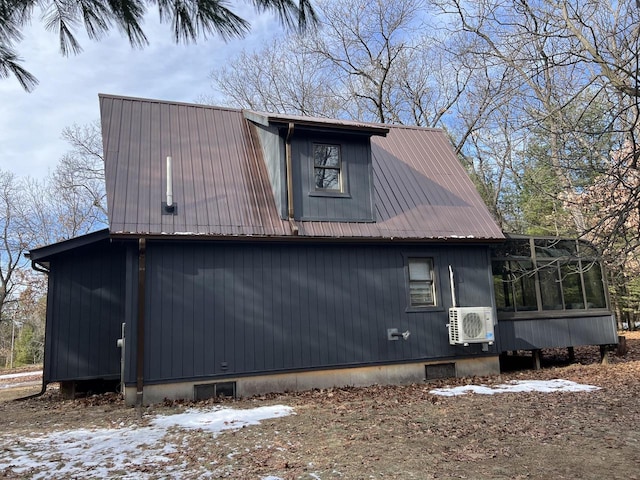 view of snowy exterior featuring a sunroom and ac unit