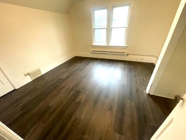 bonus room with lofted ceiling, dark hardwood / wood-style floors, and baseboard heating