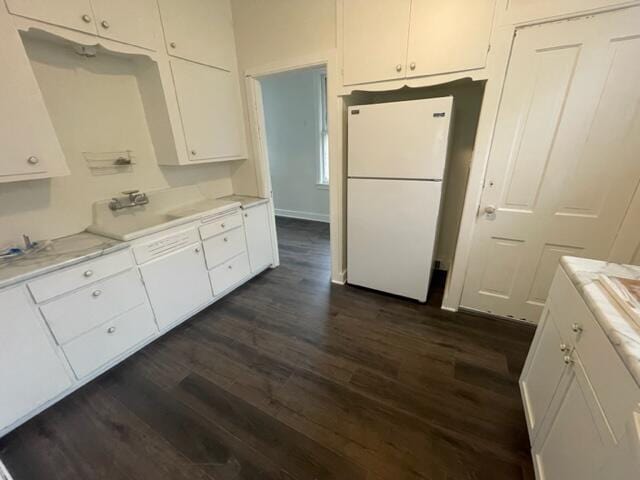 kitchen featuring dark hardwood / wood-style flooring, white cabinets, and white refrigerator