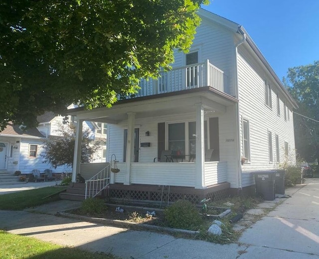 view of front of property featuring a balcony and covered porch