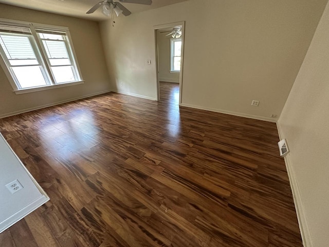 empty room featuring dark wood-type flooring and ceiling fan