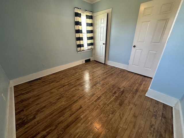 unfurnished bedroom with dark hardwood / wood-style flooring