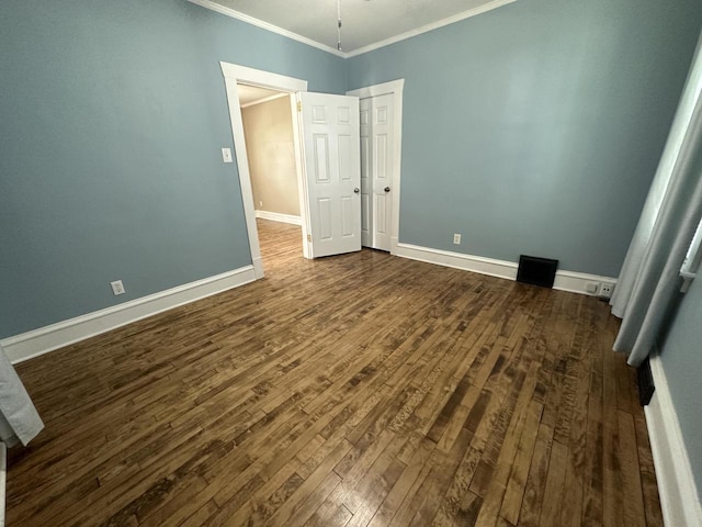 unfurnished bedroom with crown molding and dark hardwood / wood-style flooring