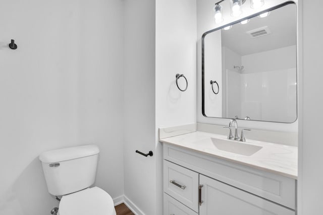 bathroom with vanity, toilet, and walk in shower