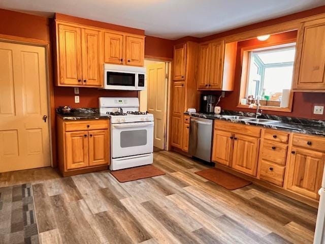 kitchen with sink, white appliances, and light wood-type flooring