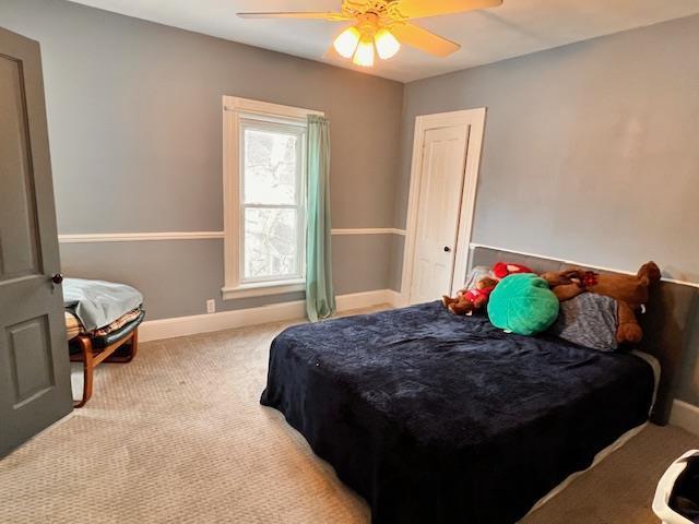 bedroom featuring light carpet and ceiling fan