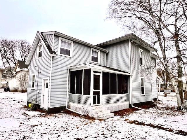 snow covered house with a sunroom