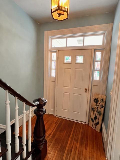 foyer entrance with a healthy amount of sunlight and dark hardwood / wood-style flooring