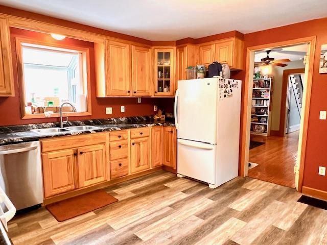 kitchen with dishwasher, sink, white fridge, ceiling fan, and light wood-type flooring