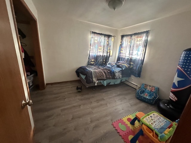 bedroom with hardwood / wood-style flooring and baseboard heating