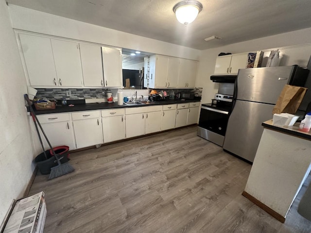 kitchen featuring white cabinetry, backsplash, light hardwood / wood-style floors, and appliances with stainless steel finishes