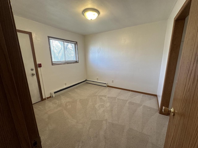 spare room with a baseboard radiator and light colored carpet