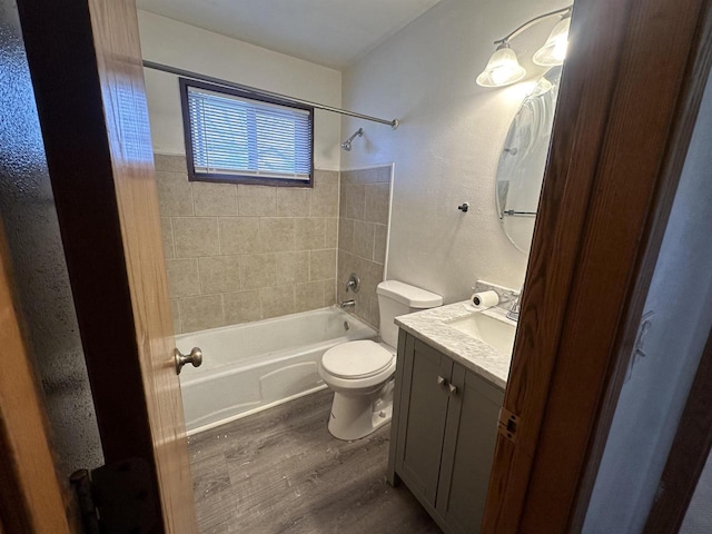 full bathroom with vanity, tiled shower / bath, wood-type flooring, and toilet