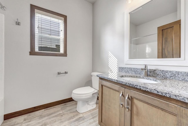 bathroom featuring hardwood / wood-style flooring, vanity, a shower, and toilet