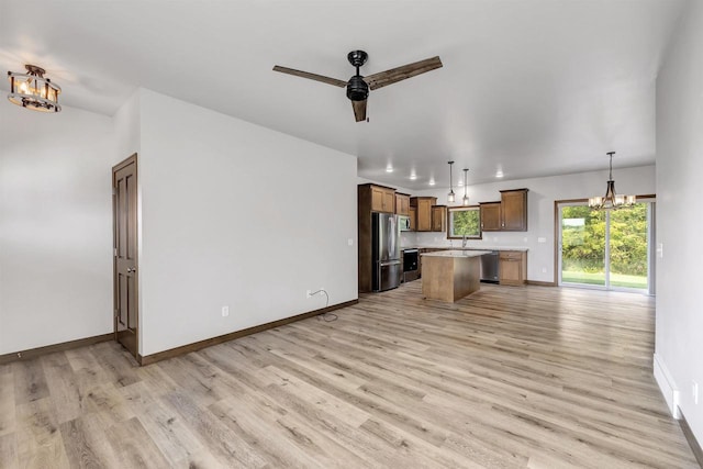 kitchen featuring light hardwood / wood-style floors, hanging light fixtures, stainless steel appliances, and a center island