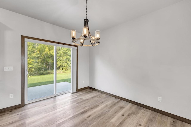 empty room featuring light hardwood / wood-style flooring and a notable chandelier