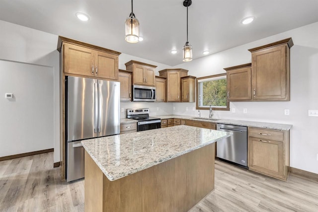 kitchen featuring appliances with stainless steel finishes, sink, hanging light fixtures, a center island, and light stone counters