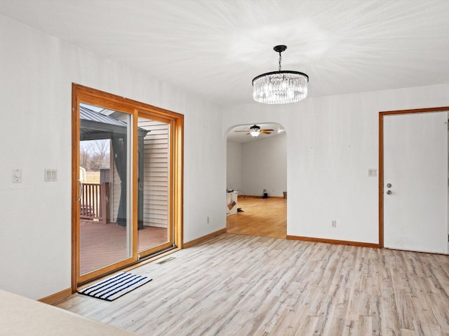 unfurnished room with a chandelier and light hardwood / wood-style flooring