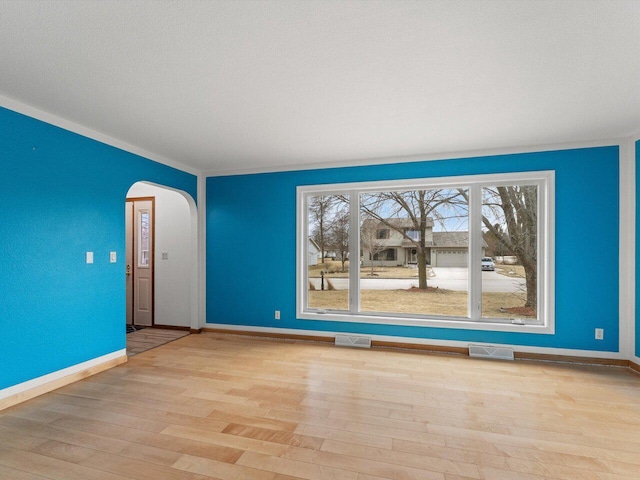 empty room with light hardwood / wood-style flooring and a textured ceiling