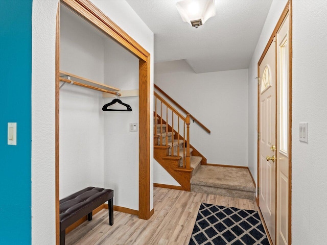 interior space featuring a textured ceiling and light wood-type flooring