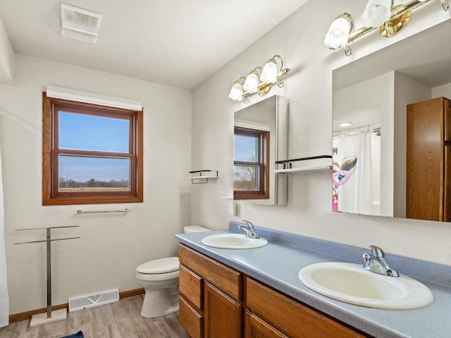 bathroom featuring hardwood / wood-style flooring, vanity, toilet, and plenty of natural light