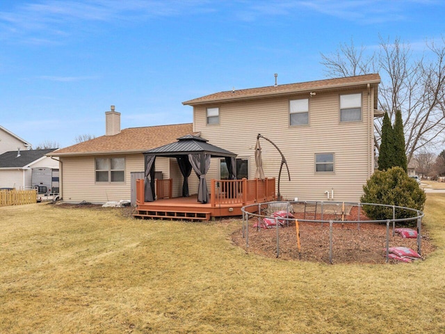 back of property with a wooden deck, a gazebo, and a yard