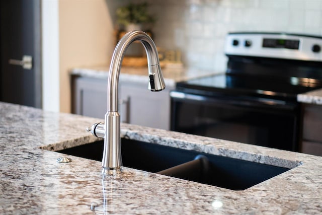 room details featuring light stone counters and stainless steel range with electric cooktop