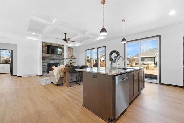 kitchen with sink, dark brown cabinets, hanging light fixtures, a center island with sink, and stainless steel dishwasher