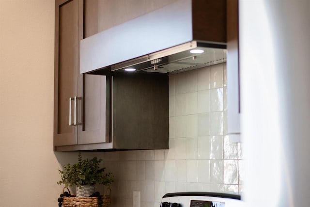 kitchen with tasteful backsplash, exhaust hood, and dark brown cabinetry